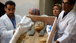 Egyptian antiquities officials uncrate a sarcophagus lid during a ceremony after its repatriation from Israel at the Egyptian Museum in Cairo