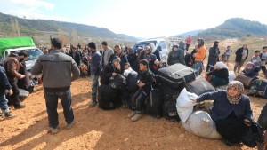 Internally displaced Syrians fleeing advancing pro-government Syrian forces wait near the Syrian-Turkish border after they were given permission by the Turkish authorities to enter Turkey, in Khirbet Al-Joz
