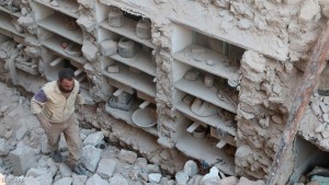 A civil defence member looks for survivors amid rubble of damaged houses after an airstrike on rebel held Old Aleppo