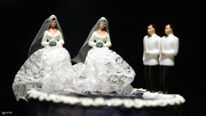 A wedding cake featuring two grooms and