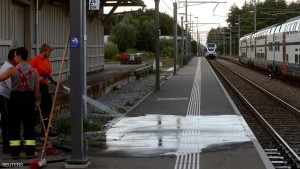 Workers clean a platform after a 27-year-old Swiss man's attack on a Swiss train at the railway station in Salez