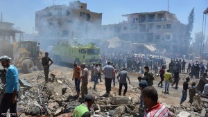 Smoke rises while people gather at a damaged site after two bomb blasts claimed by Islamic State hit the northeastern Syrian city of Qamishli