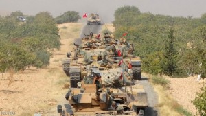 Turkish army tanks make their way towards the Syrian border town of Jarablus