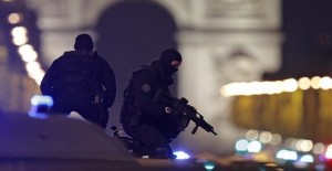 Masked police stand on top of their vehicle on the Champs Elysees Avenue after two policemen were killed and another wounded in a shooting incident in Paris