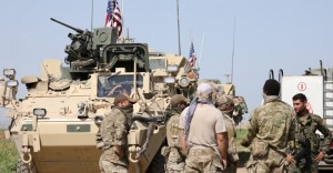 Kurdish fighters from the People's Protection Units (YPG) chat with members of U.S. forces in the town of Darbasiya