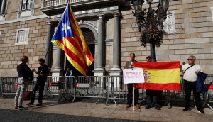 People stand with Spanish and Catalan separatist flags outside the Generalitat Palace, the Catalan regional government headquarters in Barcelona