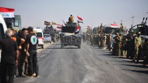 Members of Iraqi federal forces gather to continue to advance in military vehicles in Kirkuk