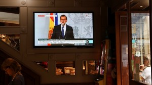 Spain's Prime Minister Mariano Rajoy is seen delivering a statement on a television screen at a bar in Barcelona