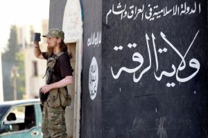 Militant Islamist fighter uses a mobile to film his fellow fighters taking part in a military parade along streets of Syria's northern Raqqa province