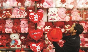 A shopkeeper hangs newly arrived stock at his shop ahead of Valentine's day in Peshawar