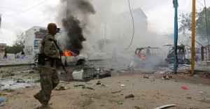 A Somali military officer secures the scene of an explosion in Maka al Mukaram road in Mogadishu