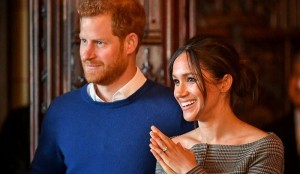 FILE PHOTO: Britain's Prince Harry and his fiancee Meghan Markle watch a performance by a Welsh choir in the banqueting hall during a visit to Cardiff Castle in Cardiff