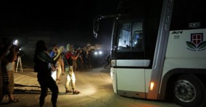 Islamist rebels from Hayat Tahrir al-Sham are seen near a bus carrying people from the villages of al-Foua and Kefraya, Syria