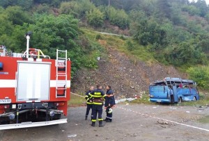 Firefighters stand at a bus crash site, near Svoge